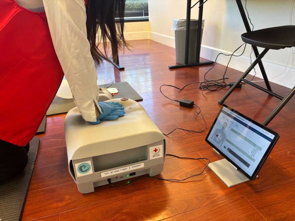 Adult CPR manikin connected to a smart-manikin learning station tablet