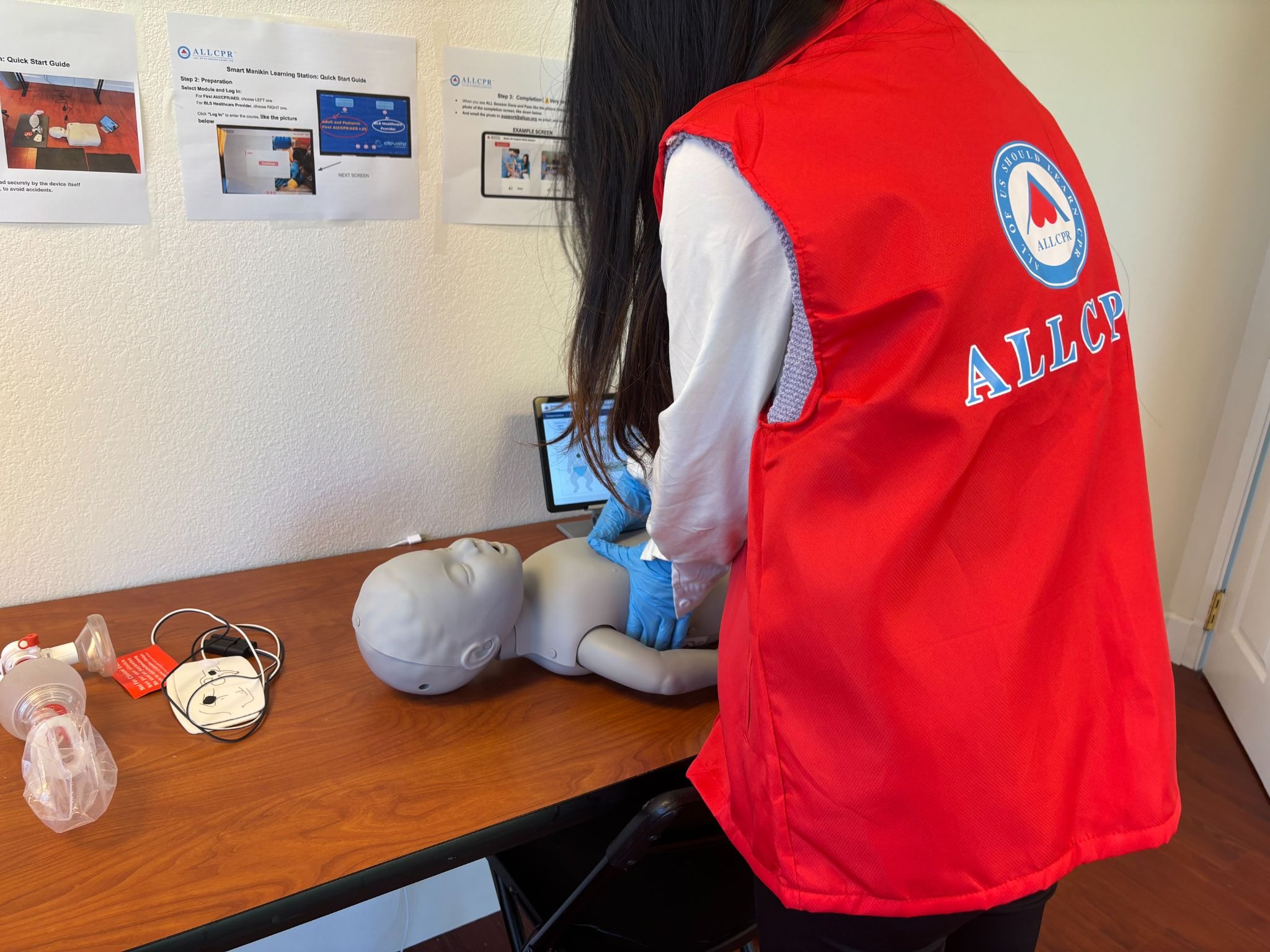 ALLCPR volunteer performing infant CPR on a training manikin